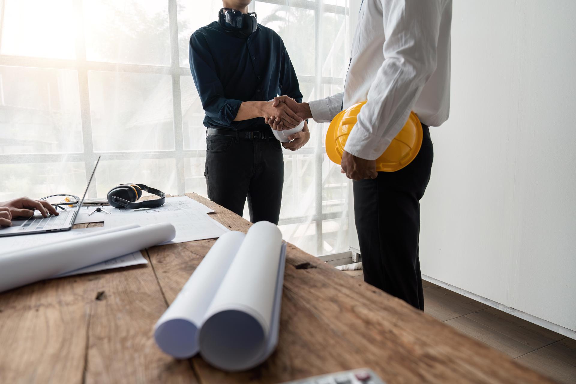 Professional Asian male engineer shaking hands with architect after meeting for agreement or contract