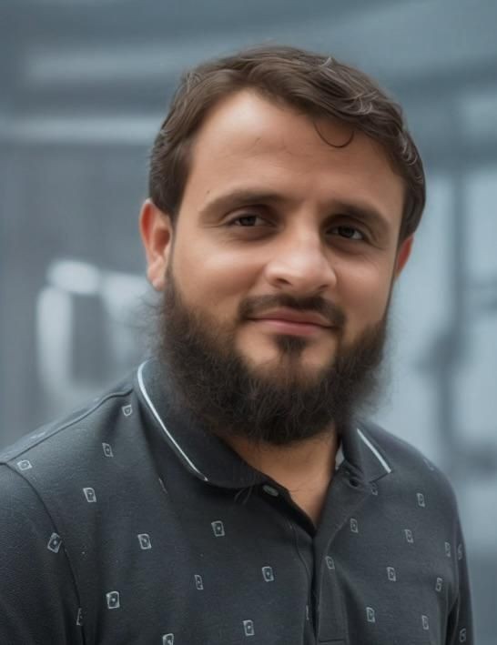 Man with a beard smiling, wearing a dark collared shirt, with a blurred background.